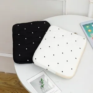 Detailed macro view of embroidered polka dot quilted laptop and tablet sleeve cases