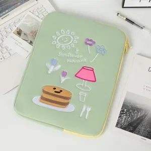 Macro view of the cute sunflower pancake embroidery on a premium green laptop sleeve