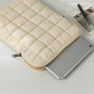 Detailansicht einer cremefarbenen gesteppten Laptoptasche mit eingelegtem Tablet