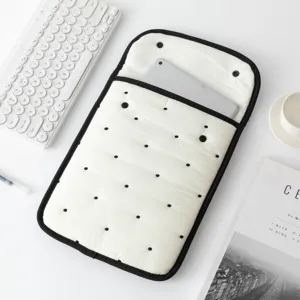 Vista detallada de la funda blanca para tableta con lunares bordados y cierre de presión