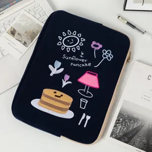 Close-up of navy blue laptop sleeve featuring cute sunflower and pancake embroidery.