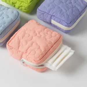 Detail view of a quilted candy-colored storage pouch showing sanitary pad storage capacity