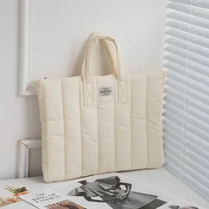 Detailansicht cremefarbene gesteppte Laptoptasche mit robusten Tragegriffen