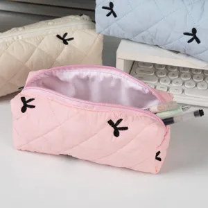 Close-up of a pink quilted large capacity pencil case with cute rabbit embroidery on a desk.