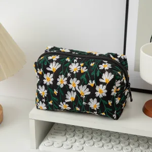 Nahaufnahme einer schwarzen Segeltuch-Kosmetiktasche mit weißen Gänseblümchen