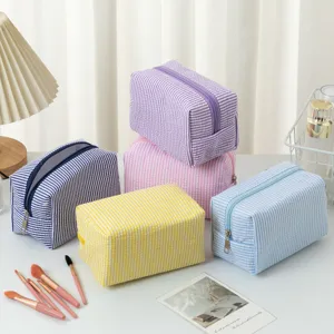 Nahaufnahme der weichen Seersucker-Textur und der kräftigen Farben der Kosmetiktaschen