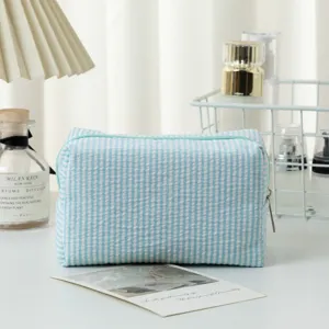 Detailansicht der blau gestreiften Seersucker-Kosmetiktasche in Lifestyle-Ambiente
