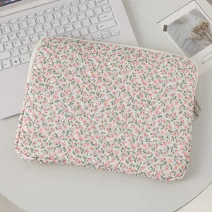 High-quality close-up of a pink floral quilted laptop sleeve on a minimalist white desk setup