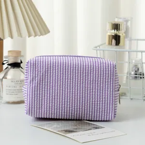 Lila gestreifte Seersucker Kosmetiktasche auf einem Schminktisch