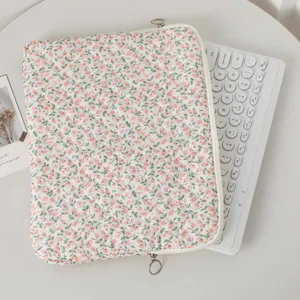 Detailed view of floral quilted laptop sleeve and white keyboard on a minimalist desk