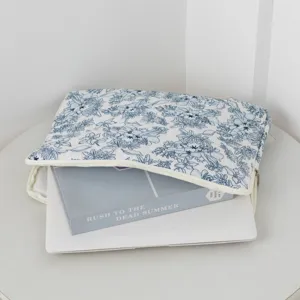 Vue détaillée d'une housse d'ordinateur matelassée aux motifs floraux bleus chic.