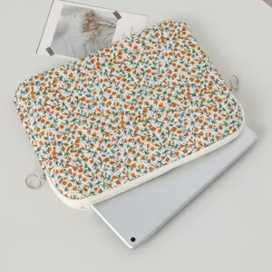Top view of floral quilted laptop sleeve with a silver laptop partially inserted