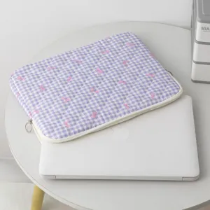 Λεπτομέρεια καπιτονέ θήκης tablet σε λεβάντα καρό με σχέδιο φιόγκους σε τραπέζι