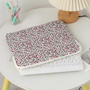 Fresh floral quilted laptop inner sleeve with zipper closure shown on a white table