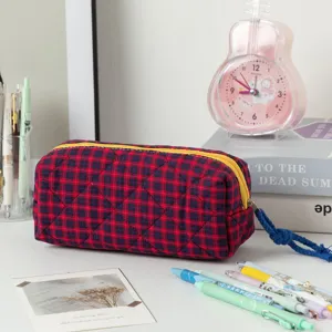 Primo piano di una borsa a scacchi rossa e blu con cerniera gialla sulla scrivania