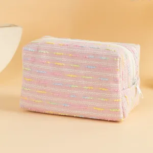 Dettaglio ravvicinato della trama intrecciata arcobaleno di questa trousse rosa