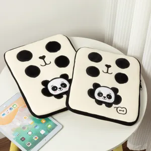 Vue détaillée des housses d'ordinateur en peluche panda sur une table blanche