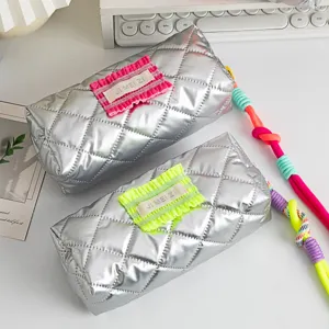 Detail showing silver quilted fabric and neon ruffle accents on pencil case