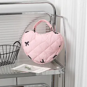 Nahaufnahme einer rosa gesteppten herzförmigen Handtasche mit schwarzer Schleifenstickerei