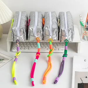 Detailed view of silver quilted pencil cases with vibrant braided rope zipper pulls
