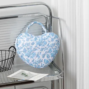 Nahaufnahme der herzförmigen gesteppten Kosmetiktasche mit blauem Blumenmuster