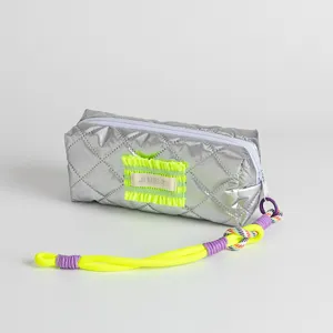 Detail view of silver quilted pencil case with neon green ruffle and colorful rope