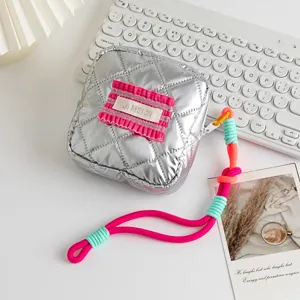 Detail of silver quilted PU mini square pouch with pink ruffle and neon lanyard.