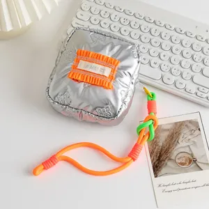 Detailed view of silver PU small square bag with orange ruffle and neon rope handle