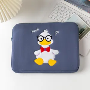 Close-up of a cute embroidered duck design on a blue padded laptop and tablet sleeve