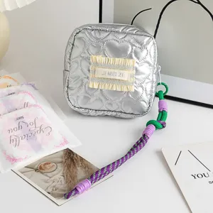 Detail of silver heart quilted PU pouch with JI MEI ZI label and braided zipper pull