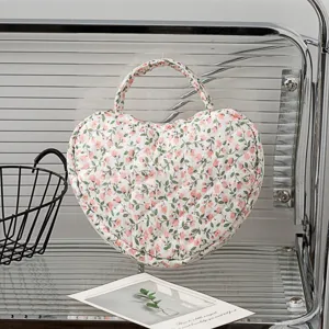 Detailansicht der gesteppten herzförmigen Kosmetiktasche mit elegantem rosa Blumendruck