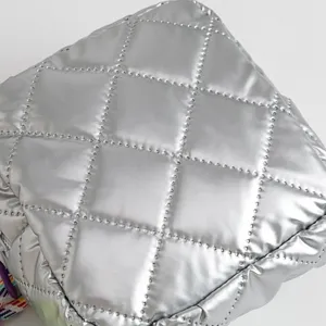 Detailed macro shot of silver quilted metallic PU fabric on a waterproof cosmetic bag
