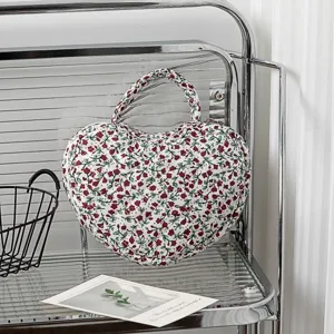 Detaillierte Nahaufnahme der herzförmigen, gesteppten Kosmetiktasche mit floralem Muster