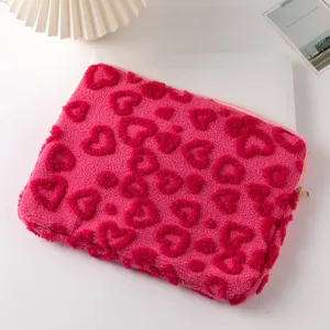 Close-up of pink plush laptop sleeve with embossed heart patterns for 11-13 inch devices