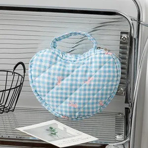 Blaue herzförmige Kosmetiktasche mit Karomuster und rosa Schleifenstickerei auf Glasregal