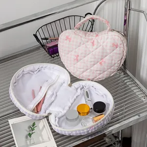 Detaillierte Innen- und Außenansicht der gesteppten herzförmigen Kosmetiktaschen in Rosa und Lila