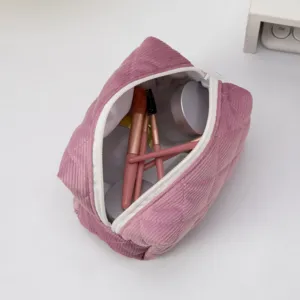 Detailed view of pink corduroy quilted makeup bag showing internal storage capacity