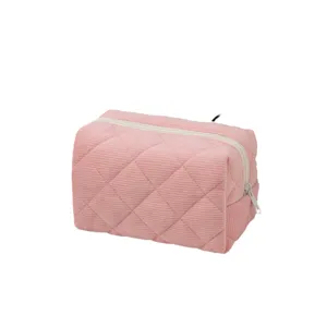 Large capacity pink corduroy quilted makeup bag with zipper closure on white background
