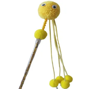 Detailed view of the cute yellow pom pom cat teaser toy wand for interactive indoor pet play.