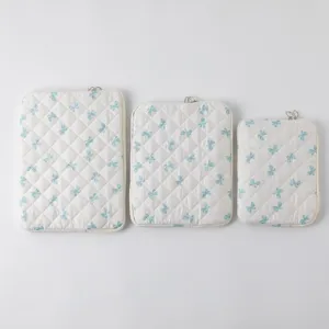 Τρία μεγέθη καπιτονέ θήκες φορητών υπολογιστών με μπλε σχέδια φιόγκου σε λευκό φόντο