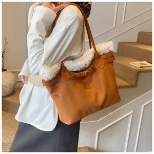 Gros plan sur un sac cabas en daim marron avec une bordure en fausse fourrure blanche