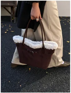 Détail du sac cabas en suédine avec garniture en fausse fourrure et boucle décorative.