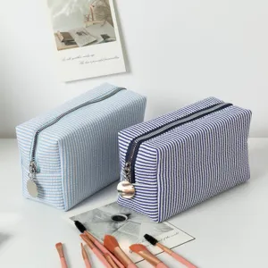 Detailansicht der blau gestreiften Seersucker-Kosmetiktaschen mit Make-up-Pinseln