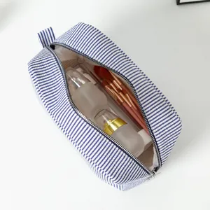 Interior view of large blue striped seersucker cosmetic bag with toiletries