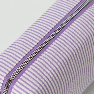 Detailansicht der lila gestreiften Seersucker-Kosmetiktasche mit Metallreißverschluss