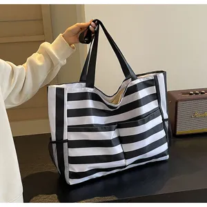 Schwarz-weiß gestreifte Tragetasche mit seitlichen Netztaschen in einer Lifestyle-Nahaufnahme