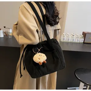 Retro striped corduroy underarm shoulder bag with cute plush pendant for daily commuting.