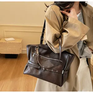 Vintage dark brown soft leather tote bag worn by a model in a stylish trench coat