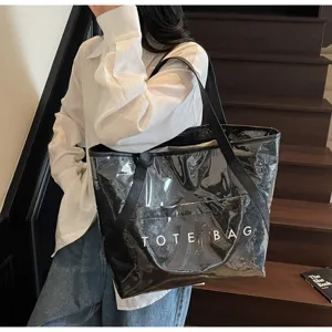 Schwarze transparente PVC-Einkaufstasche mit weißem TOTE BAG-Text, getragen von Model