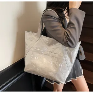 Moderner grauer DuPont-Papier-Shopper mit TOTE BAG-Aufdruck auf der Schulter